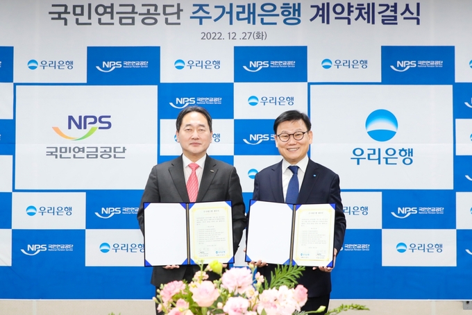 우리은행은 국민연금공단과 주거래은행 계약 체결식을 가졌다. 우리은행 이원덕 은행장(오른쪽)과 국민연금공단 김태현 이사장(왼쪽)이 계약 체결식 이후 기념 촬영을 하고 있다. (사진=우리은행)