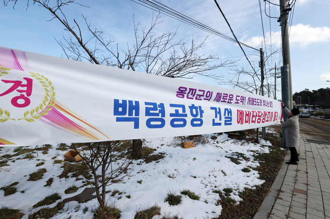 27일 인천시 옹진군 백령면 진촌1리에서 면사무소 직원들이 백령공항건설 예비타당성 통과 현수막을 걸고 있다. ( 사진 = 옹진군 제공 )
