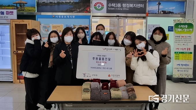 구리여고 1학년 4반 학생들이 직접 뜬 목도리 20여 개를 수택3동 행정복지센터에 전달하고 기념촬영을 했다.(사진=구리시 제공)