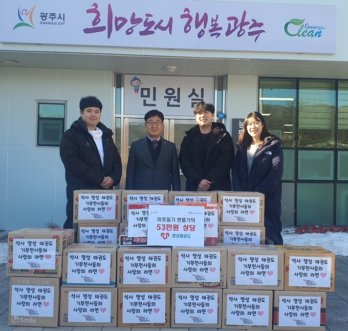 석사명성태권도 고영준 관장은 원생들과 선생님들이 어려운 이웃을 위해 전해달라며 권성덕 동장에게 물품을 전달하고 있다.(사진=광주시 제공)