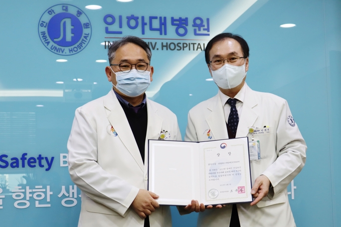 이택 인하대병원장(왼쪽)과 정한영 인천지역장애인보건의료센터장이 보건복지부의 ‘2022년 장애인 건강보건관리사업 우수사례 공모전’ 최우수상 상장을 들고 기념촬영을 하고 있다. ( 사진 = 인하대병원 제공 )