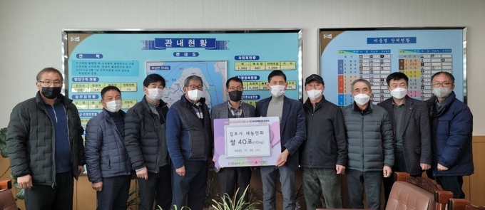김포시 새농민회 회원들이 접경지역 어려운 이웃에 10키로 쌀 40포를 전달해 달라며 귄이철 하성면장과 기념촬영을 하고 있다. (사진=하성면 제공)
