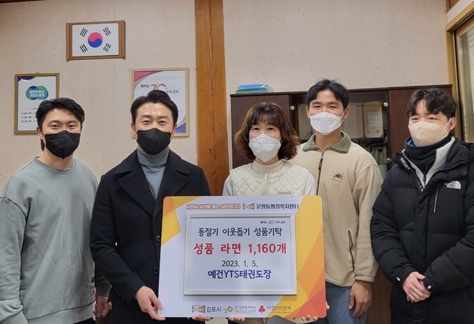 김포 운양동 예건태권도장 사범들이 김순애 운양동장에게 라면을 전달하고 있다. (사진=김포시 제공)