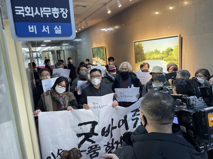9일 오전 전시 작품을 강제 철거당한 ‘2023 굿! 바이전 인 서울’ 참가 작가들이 '굿바이전 기습 작품 철거를 규탄한다'라고 적힌 현수막을 들고 국회 사무처를 점거, 항의하고 있다. (사진=고경일 굿바이전 조직위원장 제공)