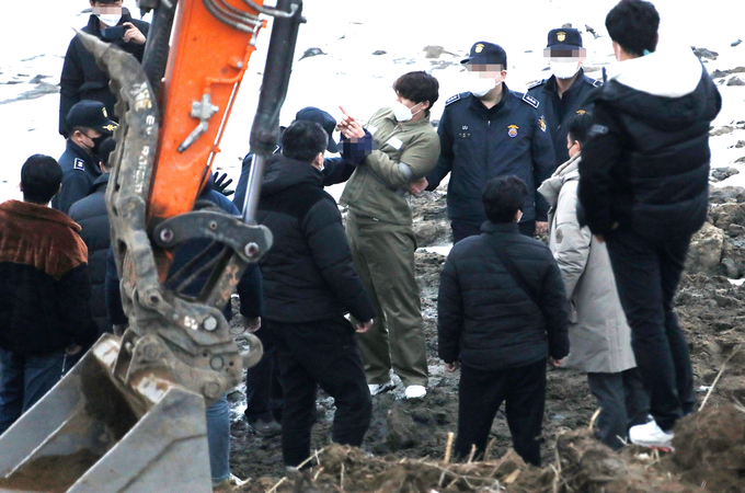  택시 기사와 동거녀를 살해한 혐의로 구속된 이기영이 6일 오후 경기도 파주 공릉천변에서 검찰 관계자들에게 시신을 매장했다고 진술한 부근을 손으로 가리키고 있다. (사진=연합뉴스)