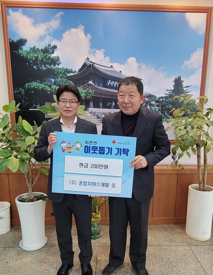 조동환 종합지하수개발대표가 석봉국 퇴촌면장에게 이웃돕기 성금을 전달하고 있다 광주시 제공