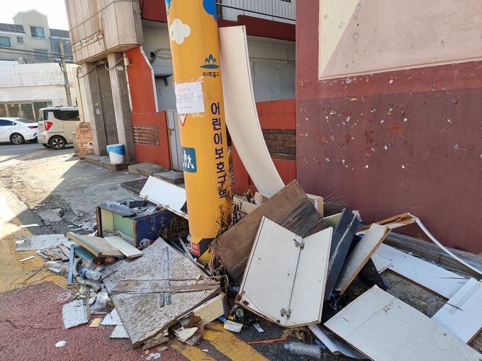 18일 오전 어린이보호구역이라고 적힌 전봇대 주변에 무단투기 쓰레기가 가득하다. ( 사진 = 김민지 기자 )