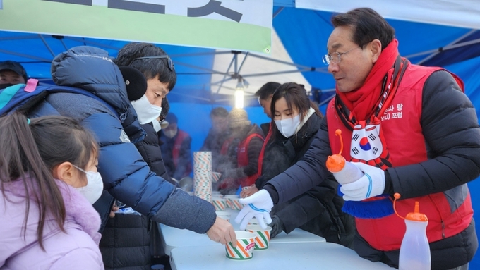 1일 오전 인천 남동구 만의골 공영주차장에서 열린 ‘사랑의 떡국 나눔’ 행사에서 유정복 시장(오른쪽)이 시민에게 떡국을 전달하고 있다. ( 사진 = 독자 제공 )