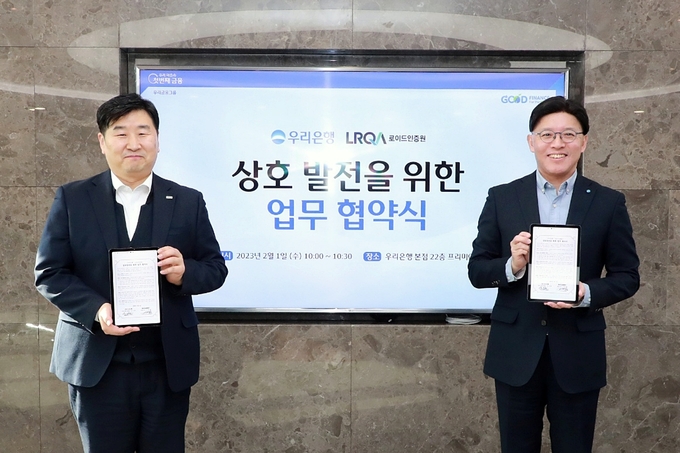 우리은행(은행장 이원덕)은 1일 서울 중구 소재 우리은행 본점에서 로이드인증원과 ESG경영 강화를 위한 업무협약을 체결했다. 우리은행 유도현 경영기획그룹 부행장(오른쪽)과 로이드인증원 이일형 대표이사가 기념촬영을 하고 있다. (사진=우리은행 제공)
