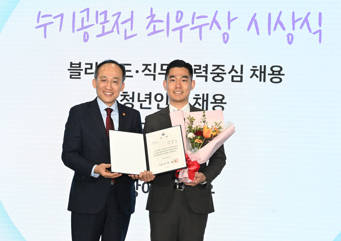 2022년 공공기관 입사수기 공모전 시상식에서 HUG 경기남부지사 이종진 선임주임(오른쪽)이 추경호 경제부총리 겸 기획재정부 장관에게 최우수상을 받고 있다. (사진=주택도시보증공사 제공)