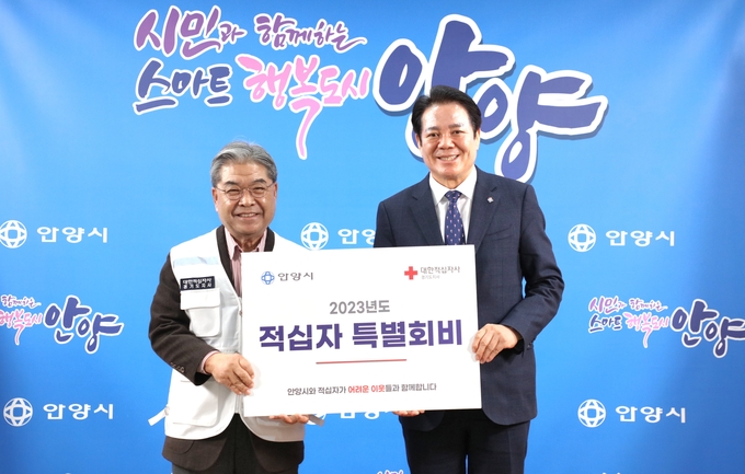 최대호 안양시장(오른쪽)이 이재정 대한적십자사 경기도지사 회장에게 적십자 특별회비를 전달하고 있다.(사진=안양시 제공)