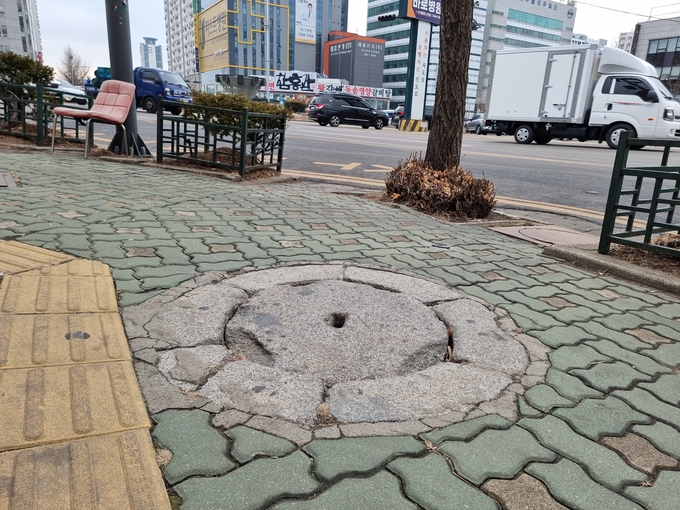 아무 문양 없이 가운데 구멍이 뚫린 석제 맨홀. ( 사진 = 김민지 기자 )