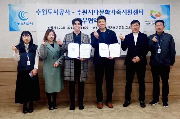 13일 오후 수원종합운동장에서 열린 '다문화가정 문화향유 확대를 위한 수원도시공사-수원시다문화가족지원센터 업무 협약식'서 두 기관 관계자들이 기념촬영을 하고 있다. (사진=수원도시공사 제공)
