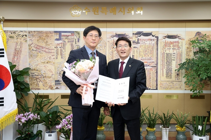  수원시의회 첫 사무관으로 승진한 이경복 팀장(좌) 김기정 수원시의회의장.(사진=수원시의회 제공) 