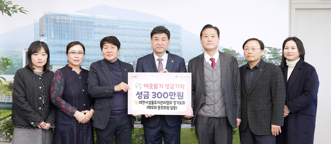 추운 겨울 취약계층을 위해 써달라며 김대동 대한시설물 유지관리협회 경기도회 대표등 동호회 회원들이 방세환시장에게 성금을 전달하고 있다. (사진=광주시 제공)