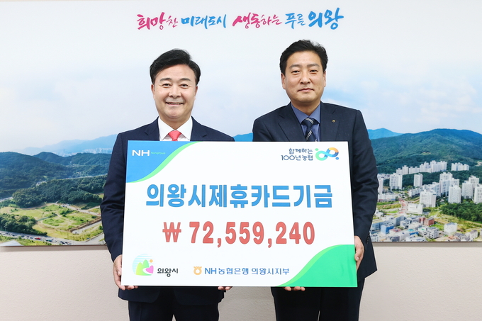김원석 NH농협은행 의왕시지부장은 지난 10일 의왕시 제휴카드기금으로 7300여만원을 김성제 의왕시장에게 전달하고 있다.(사진=의왕시 제공)