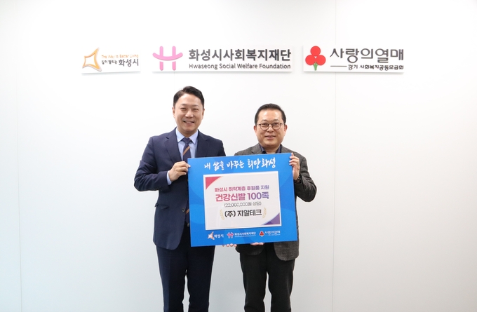  자동차 내외장 관리 전문업체인 ㈜지알테크(대표이사 김일환 (사진오른쪽)가 건강신발(100족) 을 화성시사회복지재단에 기탁했다.(사진=성시사회복지재단 제공)