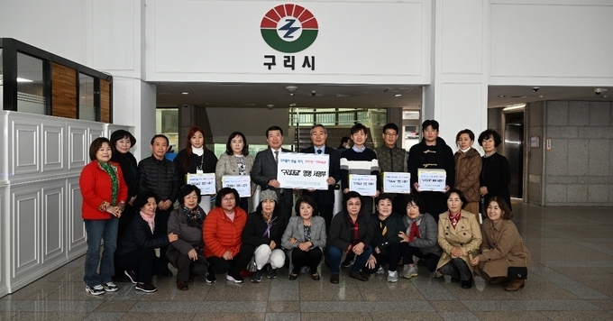 구리발전시민연대 허현수회장과 회원들이 7만 명 시민의 서명서를 백경현 구리시장에게 전달했다.(사진=구리시 제공)