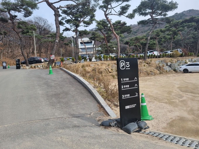 오는 4월 28일까지 원상복구하겠다고 시에 밝혀 놓고도 여전히 불법으로 주차장을 사용하면서 안내표지판도 그대로 두고 있다.(사진=이화우 기자)