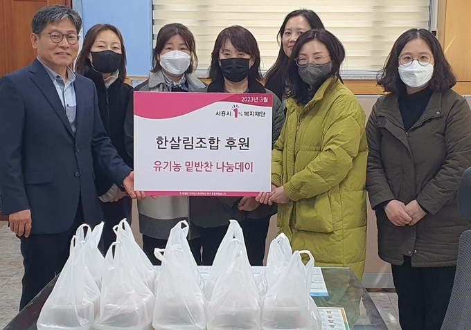 한살림 경기남부생협 회원들이 시흥시 정왕4동 행정복지센터에 어려운 이웃 위해 사랑의 밑반찬 도시락 기탁하고 있다..(사진=시흥시 제공).