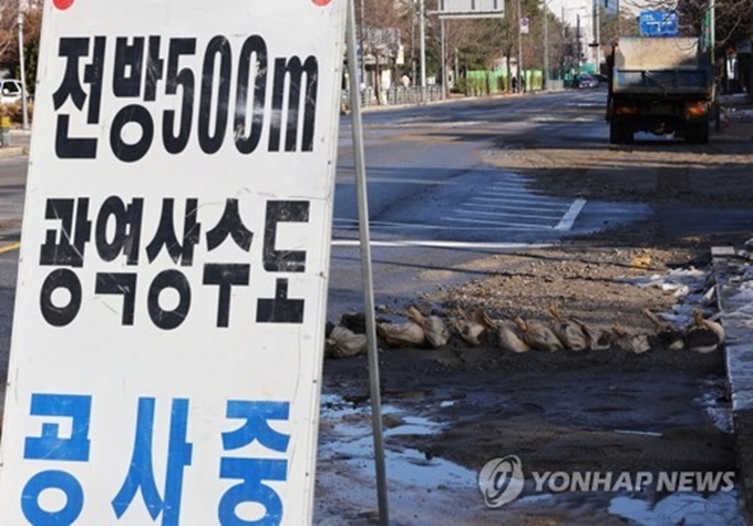 지난해 12월 25일 상수도 원수관로(정수장으로 가는 물)가 파열돼 침수된 경기도 성남시 분당구 삼평동 한 도로가 흙과 얼음 등으로 뒤덮여 있다. (사진=연합뉴스 제공)