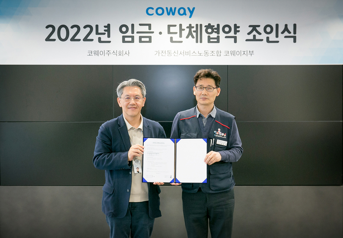 서장원 코웨이 대표이사(왼쪽)와 임창경 코웨이지부 지부장이 2022년 임금 및 단체협약 조인식을 진행하고 있다. (사진=코웨이 제공)