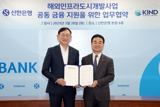 지난 28일 서울시 중구에 위치한 신한은행 본점에서 진행된 업무협약식에서 서승현 신한은행 글로벌사업그룹 부행장(왼쪽), 정기철 한국해외인프라도시개발지원공사 투자관리 본부장이 협약식 이후 기념 촬영 하는 모습. (사진=신한은행 제공)