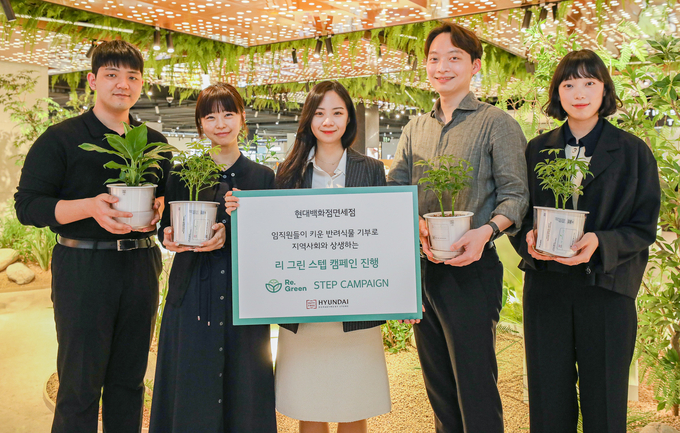 현대백화점면세점 직원들이 '반려식물 기부 캠페인'을 소개하고 있다. (사진=현대백화점그룹 제공)