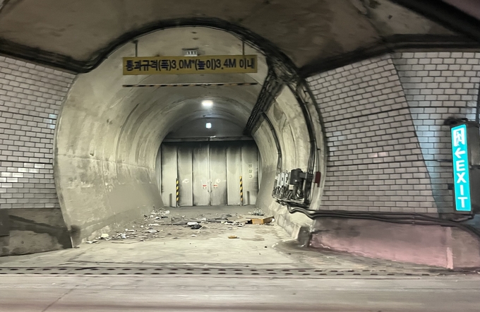 북항터널 안 차량용 비상 대피로. 앞쪽에 상자 박스 등 쓰레기가 놓여 있다. ( 사진 = 김샛별 기자 )