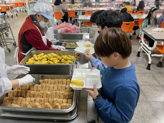 김포 유치원,초,중 통합학교 학생들이 조리사들이 사퇴하기 전 급식을 배식받고 있는 모습.(사진=독자 제공)