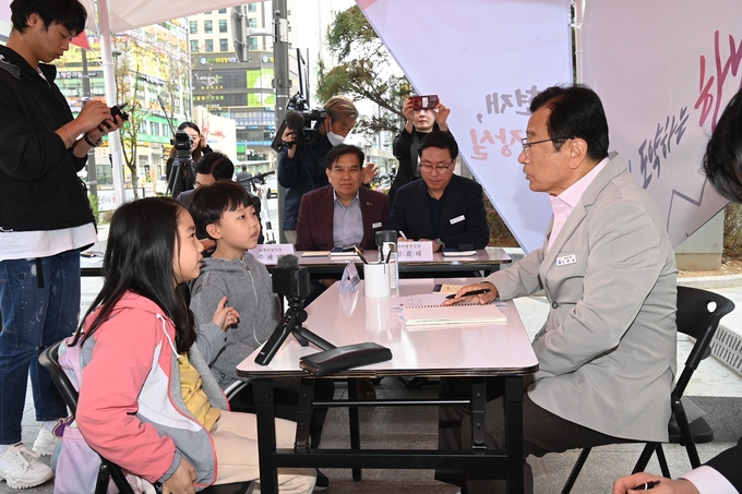 초등학생들이 이현재 시장에게 등굣길 자전거 길 확장과 아파트 단지 내 놀이터의 바닥 개선 등을 요청하고 있다. (사진=하남시 제공) 