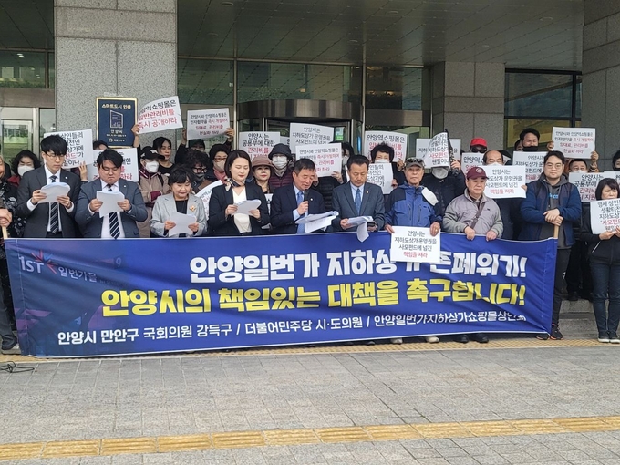 강득구 국회의원(앞줄 왼쪽 다섯번째) 등과 안양일번가 지하상가 상인들이 11일 안양시청 앞에서 기자회견을 갖고 있다.(사진=민주당 안양만안당협 제공)