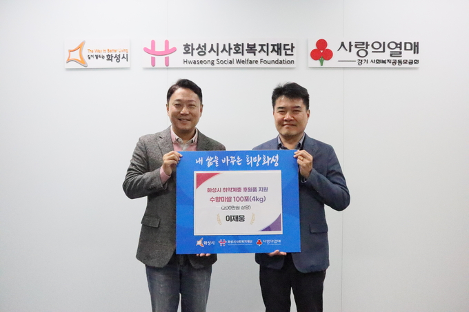 화성시 화상동에 거주하는 직장인 이재웅(사진오른쪽)씨가 어려운 이웃에 전달해달라며 쌀 100포를 화성시사회복지재단에 기탁했다( 사진제공/ 화성시사회복지재단)