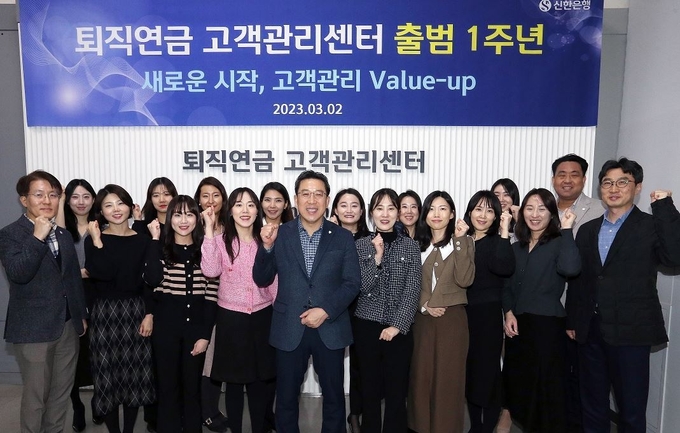 지난 3월 2일 서울시 중구 퇴직연금 고객관리센터에서 진행된 출범 1주년 기념식에서 박의식 신한은행 연금사업그룹장(가운데)과 센터 직원들이 퇴직연금 관리 역량 강화를 다짐하며 기념촬영하는 모습. (사진=신한은행 제공)