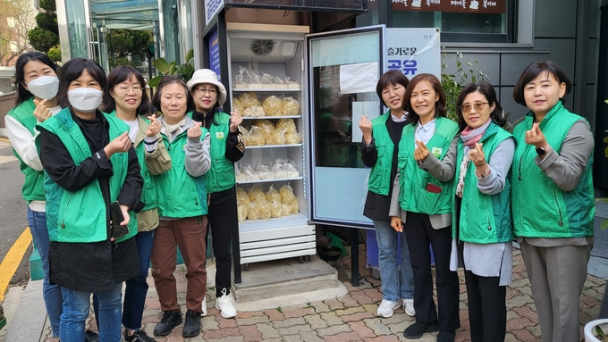 17일 수원시 매탄2동 새마을문고회는 관내 어려운 이웃을 위해 공유 냉장고에 식료품 꾸러미를 기부했다. (사진=매탄2동 제공)