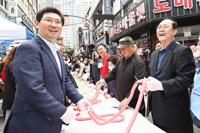 이상일 용인특례시장 지난 22일 봄맞이 축제 열린 중앙시장 찾아 상인들과 함꼐 기념찰영을 하고 있다.(사진=용인시 제공)