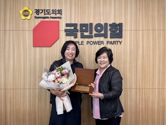 곽미숙 경기도의회 국민의힘 대표의원(왼쪽)이 윤정숙 한국유치원총연합회 경기도회장에게 감사패를 전달 받고 기념촬영을 하고 있다. (사진=경기도의회 국민의힘 제공)