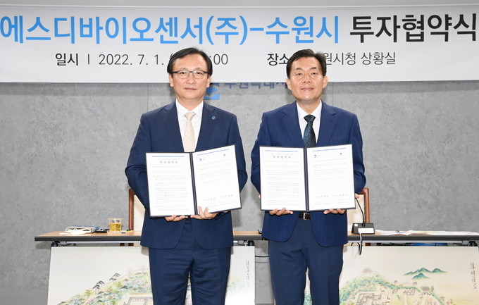 지난해 7월1일 수원시와 에스디바이오센서㈜의 투자협약식 후 이재준 수원특례시장과 이효근 대표가 협약서를 들어보이고 있다.