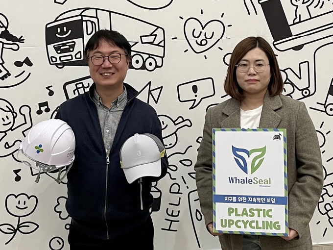 SK이노베이션이 지원·육성하고 있는 사회적기업 우시산 변의현 대표(사진 왼쪽)가 폐안전모와 폐안전모 및 폐페트병으로 만든 경량 안전모를 들고 기념사진을 촬영하고 있다. (사진=SK이노베이션)