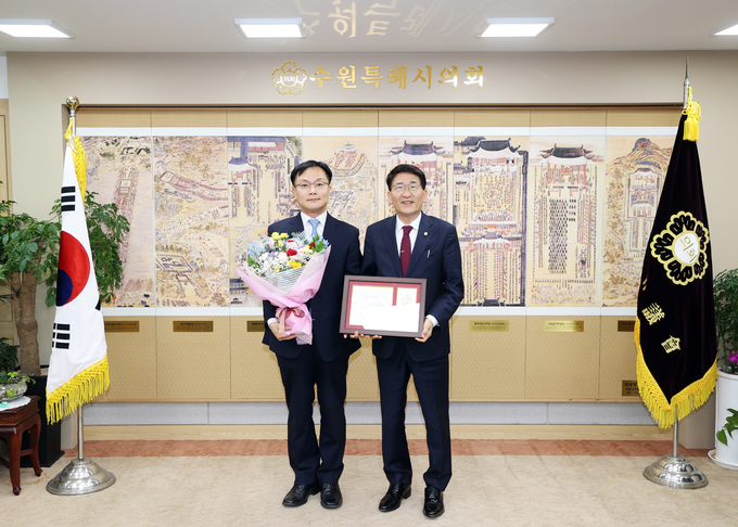 25일 수원시의회 의장 집무실에서 열린 위촉패 전달식에서 김기정 의장과 임부영 변호사가 기념 촬영을 하고 있다. (사진=수원시의회 제공)
