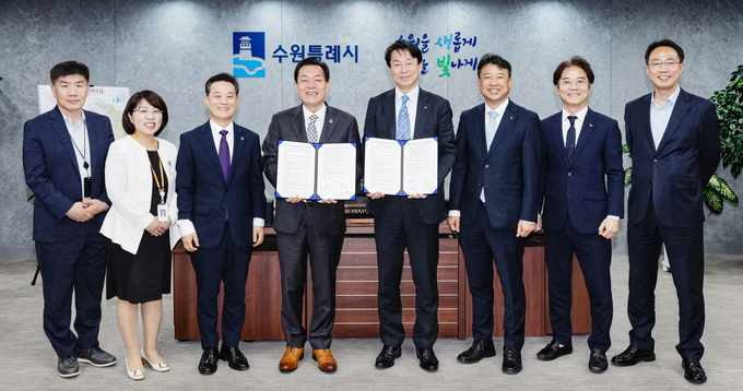 25일 수원시청에서 열린 협약식에서 이재준(왼쪽 4번째) 수원시장, 김경덕(왼쪽 5번째) SK브로드밴드 CIC장 등이 기념 촬영을 하고 있다. (사진=수원시 제공) 