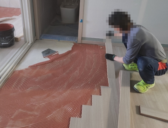 30일 수원의 한 아파트 현장에서 노동자 B씨가 마루시공을 하고 있다. (사진=독자 제공)