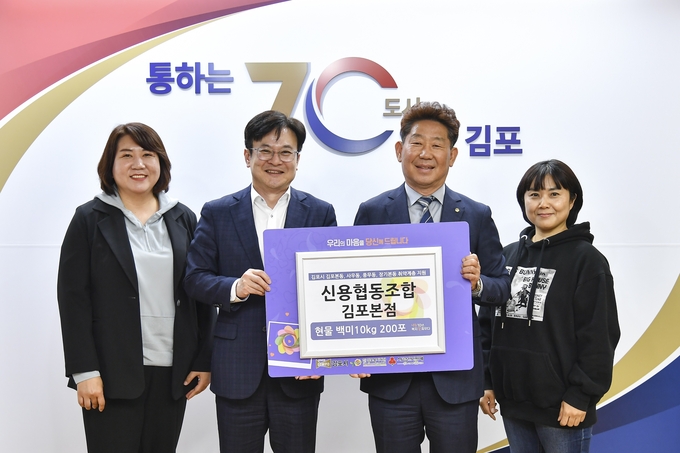  김포신협 이유식 이사장이 백미10키로 200포를 김병수 시장에게 취약계층에 전달해달라며 기부하고 기념사진을 찍고 있다. (사진=김포시청 제공)