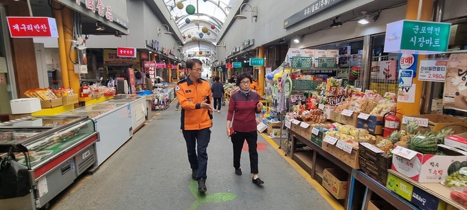 고문수 서장(사진 좌측)이 정성순 상인회장(사진 우측)과 함께 군포역전시장 화재안전컨설팅을 실시하고 있다. 사진 = 군포소방서 제공