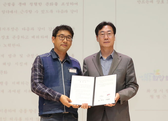 정명근 화성시장(오른쪽)과 진호창 화성시노조 지부장이 지난 3일 시청 대강당에서 ‘직장 내 갑질 및 부당지시 근절을 위해 노사 협약’을 체결하고 기념촬영. (사진 제공 /화성시)