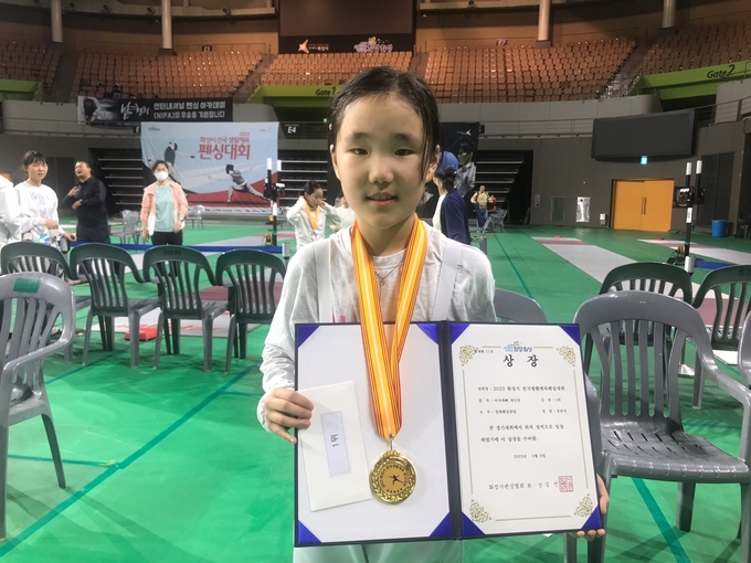 5일 화성시 화성종합경기타운 실내체육관에서 열린 ‘2023 화성시 전국생활체육 펜싱대회’ 여자초등 저학년부 에뻬 개인전에서 금메달을 목에 건 정윤아(알레펜싱클럽)가 기념사진을 찍고 있다. (사진=유창현 기자)
