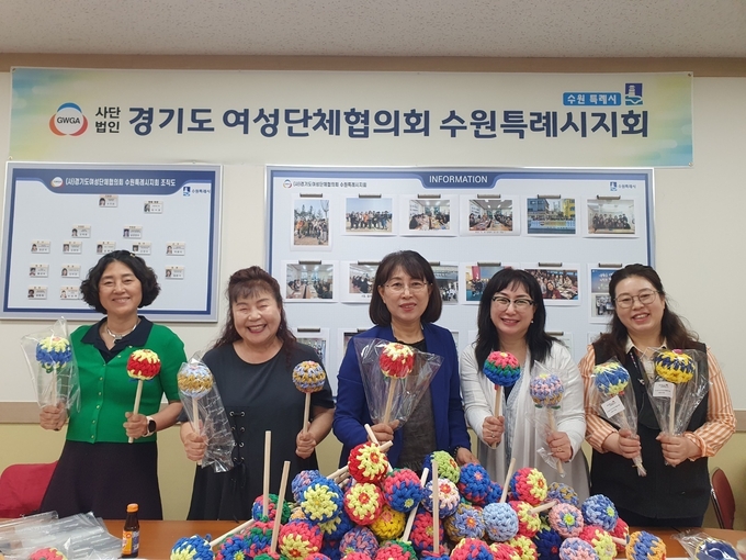  소진순(가운데) 지회장과 회원들이 직접 제작한 효도봉을 들고 있다. (사진=수원여성단체협의회 제공)