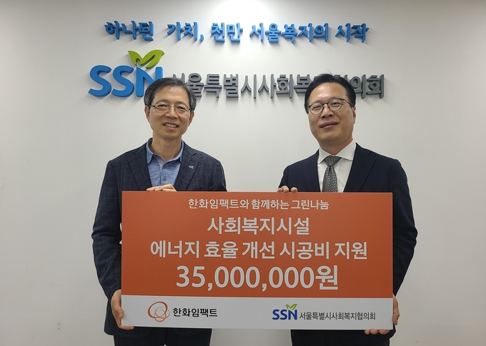 김홍기 한화임팩트 사업지원담당(오른쪽)이 전명수 서울특별시사회복지협의회 사무총장에게 기부금을 전달하고 있다. (사진=한화임팩트 제공)