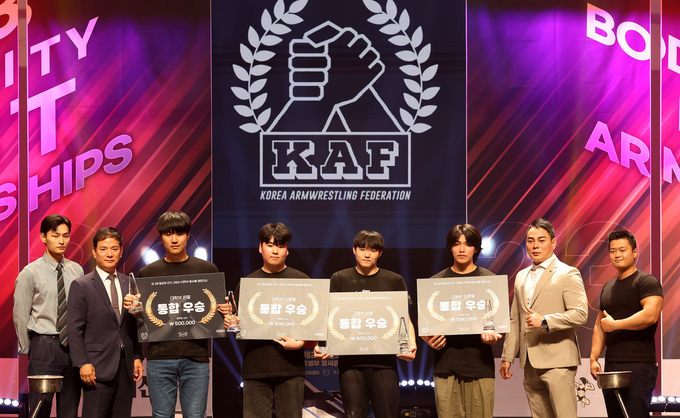 13일 인천 글로벌캠퍼스 대강당에서 열린 제2회 팔씨름 챔피언십 팔로워 대회 왕중왕전 챔피언들이 관계자들과 기념촬영을 하고 있다.