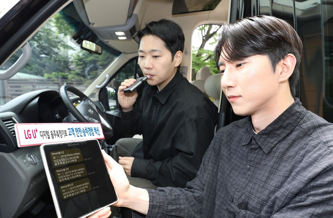 LG유플러스 임직원이 전세버스에 장착된 디지털 음주측정기를 시연하는 모습. (사진=LG유플러스 제공)